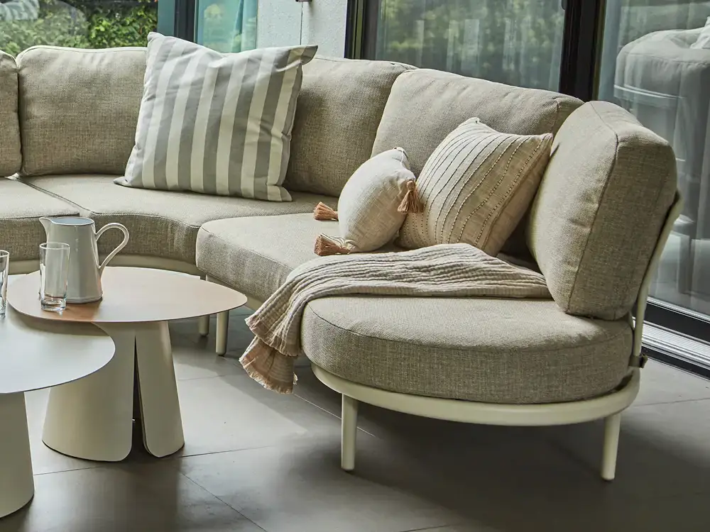 Sofa sectionnel arrondi Sora crème avec coussins décoratifs Artovi.